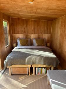 a bedroom with a bed in a wooden wall at Cross Farm Retreat in Todmorden