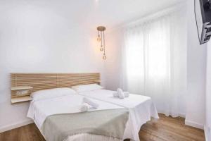biała sypialnia z dużym łóżkiem z białą pościelą w obiekcie Precioso apartamento en el centro de Nerja w mieście Nerja