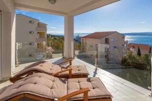 a balcony with two beds and a view of the ocean at WHITE HOUSE PENTHOUSE in Dramalj