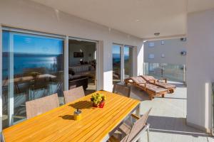 a dining room with a table and chairs on a balcony at WHITE HOUSE PENTHOUSE in Dramalj