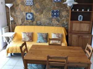 a wooden table and chairs in a room with a couch at Senya Salvi 12 CostaBravaSi in Sant Feliu de Guixols