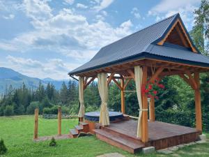 a wooden gazebo with a roof on a field at Willa Na Polanie z Jacuzzi in Kościelisko