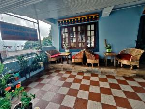 a porch with wicker chairs and tables in a building at Hotel Buddha Mitra in Ravangla