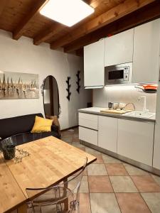 a kitchen and dining room with a table and a couch at Accogliente appartamento in centro Brescia in Brescia +6 photos