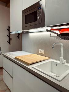 a kitchen with a sink and a microwave at Accogliente appartamento in centro Brescia in Brescia
