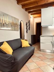 a black couch with yellow pillows in a living room at Accogliente appartamento in centro Brescia in Brescia