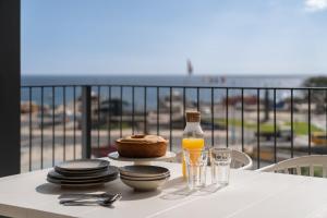 einen Tisch mit einer Flasche Orangensaft sowie Teller und Gläser in der Unterkunft Savoy Insular V by An Island Apart in Funchal