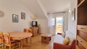 una sala de estar con una mesa y un sofá en Apartments Barbalic D, en Baška