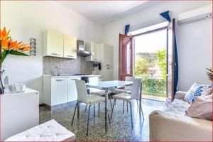 a kitchen and living room with a table and chairs at Casa Martina a Porto Azzurro in Porto Azzurro