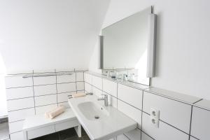 a white bathroom with a sink and a mirror at Hotel Landgasthof zum Kaffelstein in Kreuzwertheim