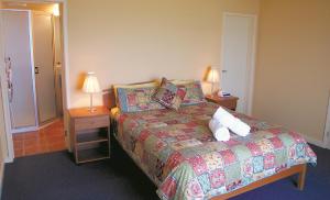 a bedroom with a bed with pillows and two lamps at Horizons Beachfront Apartment in Port Fairy