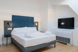 a bedroom with a large bed and a flat screen tv at 20Miglia Albergo Diffuso - Via Giovanni Di Prima in Catania