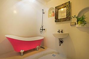 a bathroom with a red tub and a sink at Flower House B&B in Jiufen