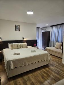 a bedroom with a large bed and a couch at Hotel Ruža in Međugorje