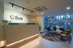 an office lobby with a counter and a table at Olive Hotel Kundalahalli by Embassy Group in Bangalore