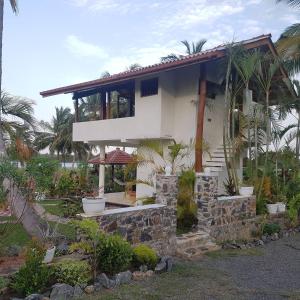 a house on the beach with palm trees at Lake Villa near Udawalawe National Park in Pahalagama