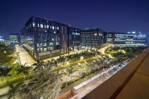 a city at night with buildings and palm trees at Olive Hotel Kundalahalli by Embassy Group in Bangalore