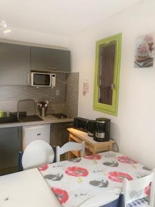 a kitchen with a table and a table and chairs at Dans une station thermale, Studio dans résidence avec ascenseur in Amélie-les-Bains-Palalda
