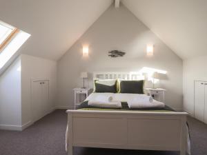 a bedroom with a white bed in a attic at Loch View in Breaclete