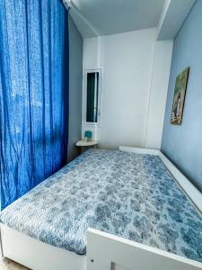 a bedroom with a large bed with a blue curtain at Villetta sullo Scoglio in Gela