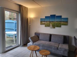 a living room with a couch and a table at Ferienhaus Seeperle in Tossenserdeich