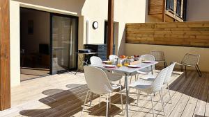 Una mesa blanca y sillas en un patio. en U Paradisu - Magnifique T4, les pieds dans l'eau, en Viagenti