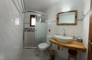 a bathroom with a sink and a toilet and a shower at Tiki Rooms in Marathokampos