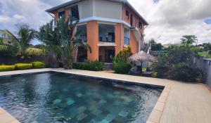 a house with a swimming pool in front of a house at RésidenceSuisse Roof-Top in Nosy Be