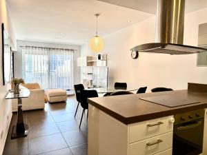 une cuisine et un salon avec une table et des chaises dans l'établissement Sliema 1BDR Apartment with Pool Access and off Seafront, à Sliema 5 autres photos
