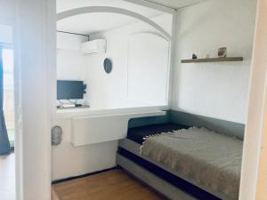 mały pokój z łóżkiem i biurkiem w obiekcie Hyeres port bel appartement w Hyères
