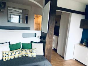 sypialnia z łóżkiem z zielonymi i białymi poduszkami w obiekcie Hyeres port bel appartement w Hyères