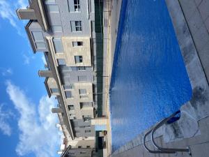 a tall building with a swimming pool next to it at Dúplex Nalón in San Juan de la Arena