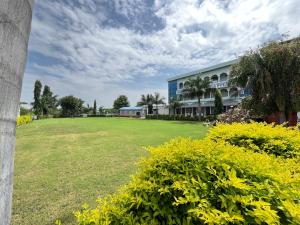 un grande prato di fronte a un edificio di SD Family Resort CLUB-BAR&SPA l just 7km from shreenathji Nathdwara by SK 966o9o1oo6 a Nathdwara