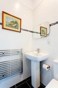 a white bathroom with a sink and a mirror at Veeve - Richmond on Canvas in Richmond upon Thames +9 photos