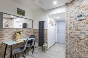 uma sala de jantar com mesa e cadeiras e uma parede de tijolos em Dolce Dormire em Castiglione del Lago