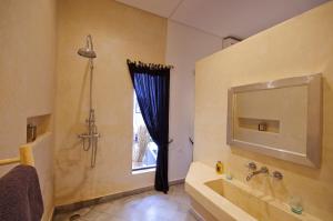 a bathroom with a tub and a sink and a mirror at Riad Kasbah 117 in Marrakech +47 photos