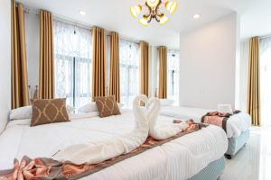 a bedroom with two beds with swans on them at Home in Phuket in Ban Phlu Yai
