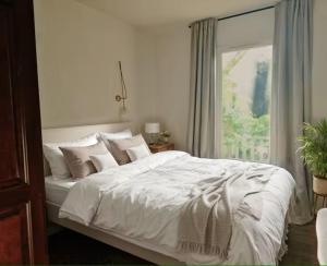 a bedroom with a white bed and a window at Petite Villa La Pantoufle au Domaine du Golf de Pinsolle in Soustons +18 photos