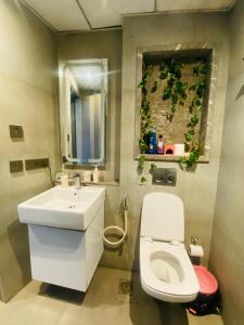 een badkamer met een wit toilet en een wastafel bij Gaylords Ganges Assi Varanasi retreat in New Delhi