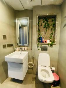 een badkamer met een wit toilet en een wastafel bij Gaylords Ganges Assi Varanasi retreat in New Delhi +13 foto's