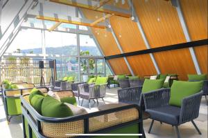 un ristorante con sedie, tavoli e finestre verdi di Luxury Genting Studio Suite with Swimming Pool and Netflix a Resorts World Genting