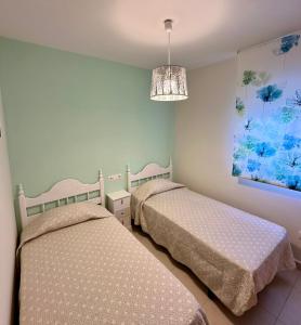 a bedroom with two beds and a painting on the wall at Impresionante Ático en Torre del Mar frente al Mar in Torre del Mar +13 photos