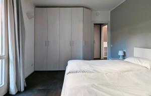 una camera da letto con un letto, armadi bianchi e una finestra di La piccola coccinella a Bellagio