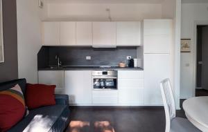 una cucina con armadi bianchi e un soggiorno con divano. di La piccola coccinella a Bellagio