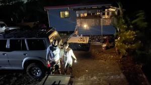 two men standing in front of a house at night at GME's Little Farm in Pililla
