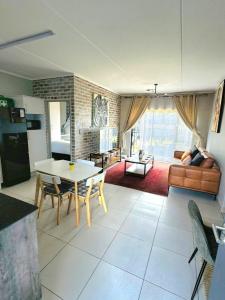 a living room with a table and a couch at Lakhe Lethu Apartment: Green Valley Estate in Nelspruit