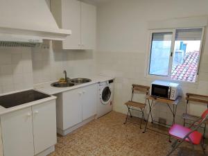 a kitchen with a sink and a washing machine at Apartamentos Franciscanos in Albacete