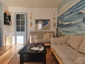 a living room with a couch and a table at Petite Villa La Pantoufle au Domaine du Golf de Pinsolle in Soustons