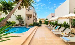 a pool at a hotel with lounge chairs and umbrellas at Ferienhaus Für 28 Personen In Skaleta, Kreta Nordküste Kretas in Skaleta