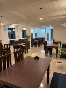 a dining room with wooden tables and chairs at Hardev Residency in Pathyar